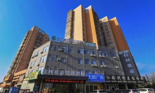 a tall building with a sign on the side of it at GreenTree Inn Express Fuyang University Town West High-Speed Railway Station in Fuyang