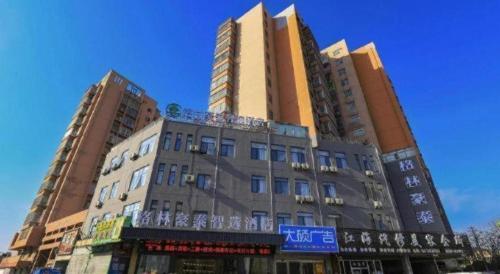 a building with two tall buildings in a city at GreenTree Inn Express Fuyang University Town West High-Speed Railway Station in Fuyang