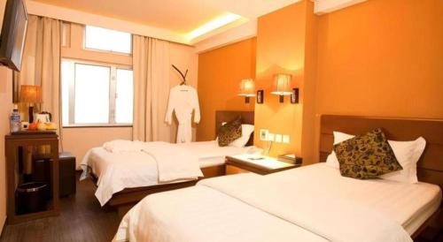 a hotel room with two beds and a window at Sunny Day Hotel in Hong Kong