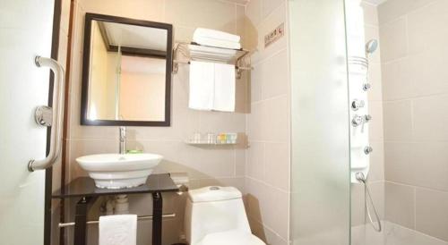 a bathroom with a sink and a toilet and a mirror at Sunny Day Hotel in Hong Kong