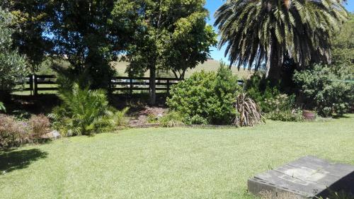 a yard with a fence and a field of grass at Waters Edge B&B in Kaitaia