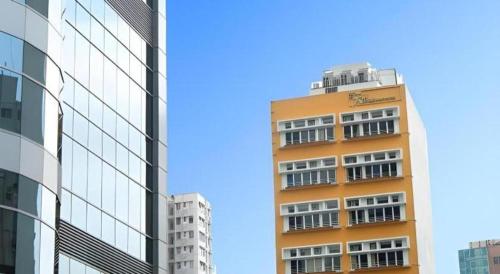a tall orange building next to two other buildings at Sunny Day Hotel in Hong Kong