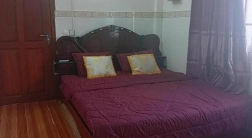 a bedroom with a bed with a purple blanket and pillows at Unique Hotel in Phnom Penh