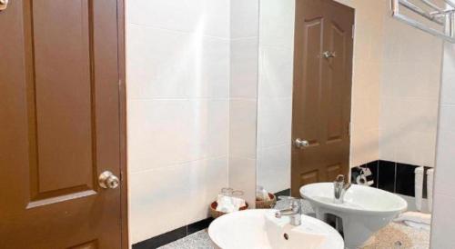 a bathroom with two sinks and a toilet in it at Siamtara Palace Hotel in Maha Sarakham