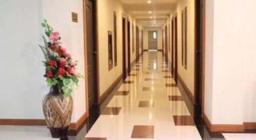a hallway with a vase with flowers in it at Siamtara Palace Hotel in Maha Sarakham