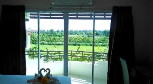 a bedroom with a window with a view of a yard at Siamtara Palace Hotel in Maha Sarakham