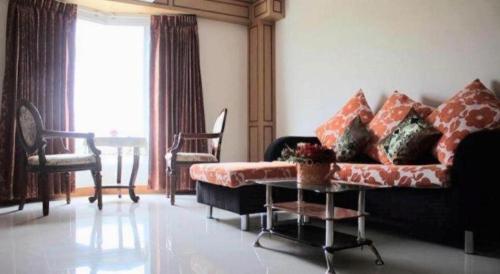 a living room with a couch and a table at Siamtara Palace Hotel in Maha Sarakham