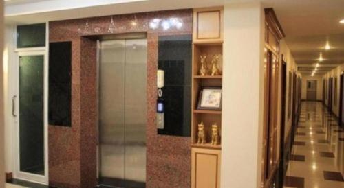 a hallway of a building with a door and shelves of vases at Siamtara Palace Hotel in Maha Sarakham
