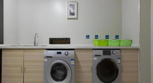 a kitchen with a washing machine and a sink at City Comfort Inn Wuhan Jiefang Avenue Xinrong Light Rail Station in Wuhan