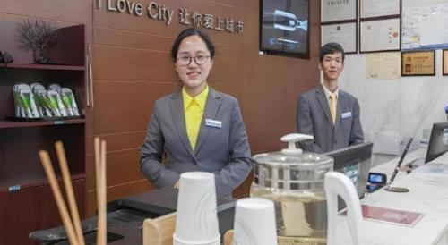 two men in suits sitting at a counter in a store at City Comfort Inn Wuhan Jiefang Avenue Xinrong Light Rail Station in Wuhan