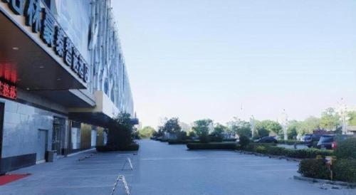 an empty street in front of a building at GreenTree Inn Express Jiangsu Taizhou North High-Speed Railway Station 