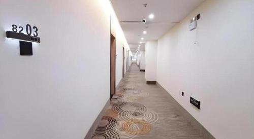 a hallway with a long hallway with a spiral tile floor at GreenTree Inn Express Jiangsu Taizhou North High-Speed Railway Station 