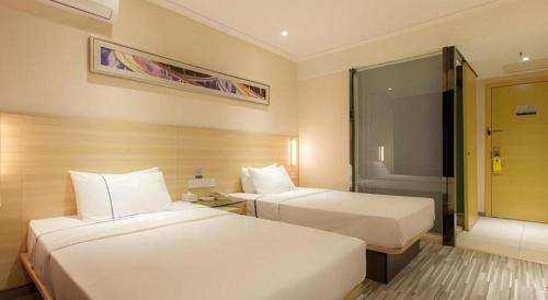 a hotel room with two beds and a window at City Comfort Inn Wuhan Jiefang Avenue Xinrong Light Rail Station in Wuhan