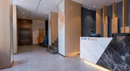 a lobby of an office with a counter and chairs at ZMAX Hotels Shenzhen Lianhuacun Metro Station in Shenzhen