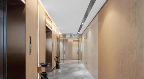 a hallway in a building with a long hallway with doors at Lavande Hotel Guangzhou Quzhuang Metro Station in Guangzhou