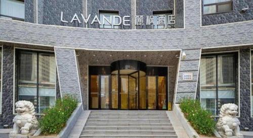 a building with two lion statues in front of it at Lavande Hotel Changchun Gaoxin Jilin University in Changchun