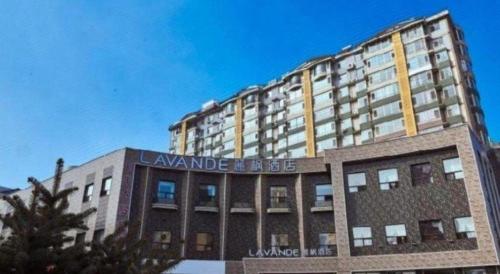 a large building with a sign on top of it at Lavande Hotel Changchun Gaoxin Jilin University in Changchun