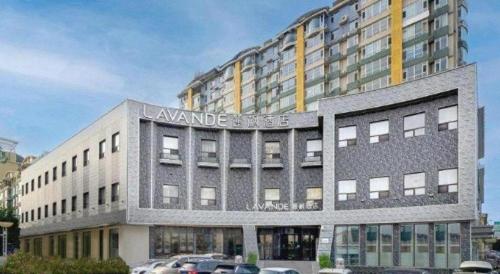 a large building with cars parked in front of it at Lavande Hotel Changchun Gaoxin Jilin University in Changchun