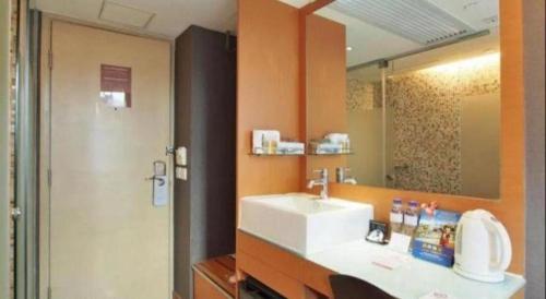 a bathroom with a sink and a mirror at J Link Hotel in Hong Kong