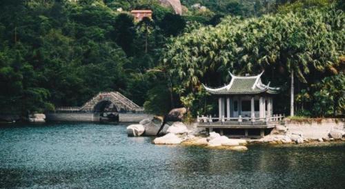 a bridge over a lake with a building in the water at Xiamen Seashine Lakeview Hotel in Xiamen