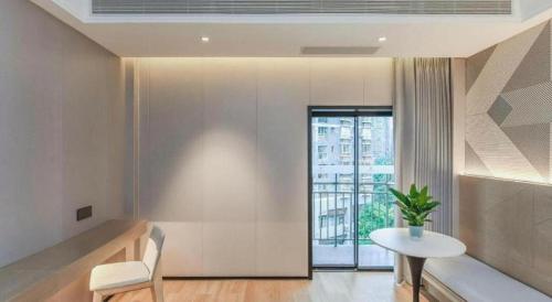 a living room with a table and a window at Borrman Hotel Chongqing Bishan Central Street in Chongqing
