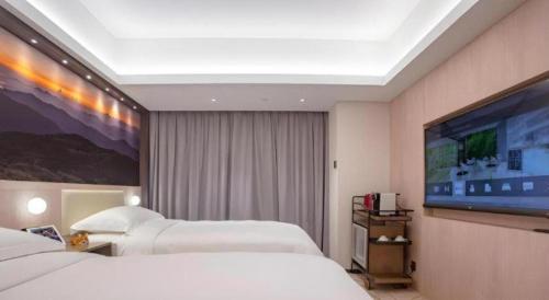 a hotel room with two beds and a flat screen tv at OASIS AVENUE-A GDH HOTEL in Hong Kong
