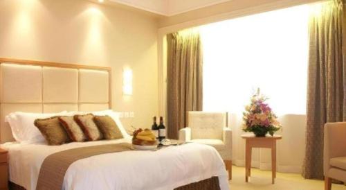 a bedroom with a bed and a chair and a window at OASIS AVENUE-A GDH HOTEL in Hong Kong