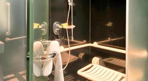a bathroom with a mirror and a toilet with towels at OASIS AVENUE-A GDH HOTEL in Hong Kong