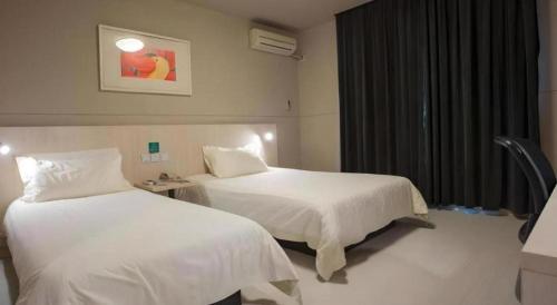 a hotel room with two beds and a window at Jinjiang Inn Shenzhen Airport in Shenzhen