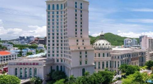 a tall white building in the middle of a city at Sanya Baohong Hotel in Sanya