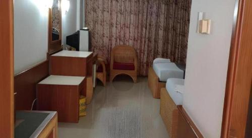 a room with a room with a tv and a couch at Pailyn Hotel in Sukhothai