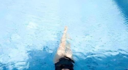 a person swimming in the water with their leg in the water at Grand Surya Hotel Kediri in Kediri