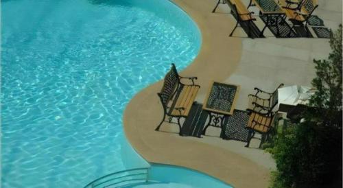 a painting of a swimming pool with chairs next to it at V-One Hotel Korat in Nakhon Ratchasima