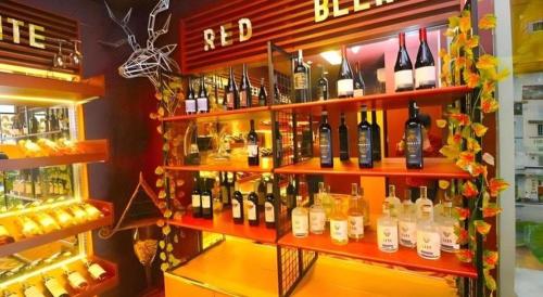 a shelf filled with lots of bottles of wine at Grand Surya Hotel Kediri in Kediri