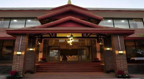 a building with a porch and stairs in front of it at Piyaporn Hill Paradise Hotel in Mae Sai