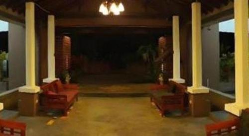 a living room with columns and red couches at Natee Place in Chiang Mai