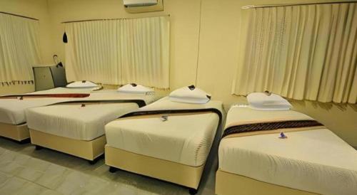 a group of four beds in a room at Piyaporn Hill Paradise Hotel in Mae Sai