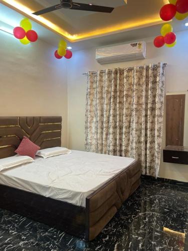 a bedroom with a bed with balloons on the ceiling at Shri Sanwariya Dham Near By Mathura Junction Railway Station in Mathura