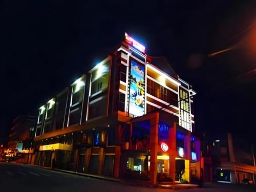 a building with a neon sign on it at night at MO2 Westown Hotel San Juan in Bacolod