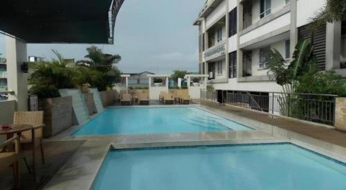 a large blue swimming pool next to a building at MO2 Westown Hotel San Juan in Bacolod