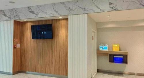 a hallway with a wooden door with a television on it at Goodrich Hotel in Hong Kong