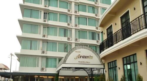 a large building with a sign in front of it at Aramis Hotel in Nakhon Sawan