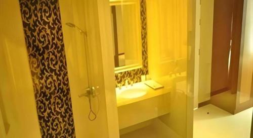 a bathroom with a sink and a mirror at Aramis Hotel in Nakhon Sawan
