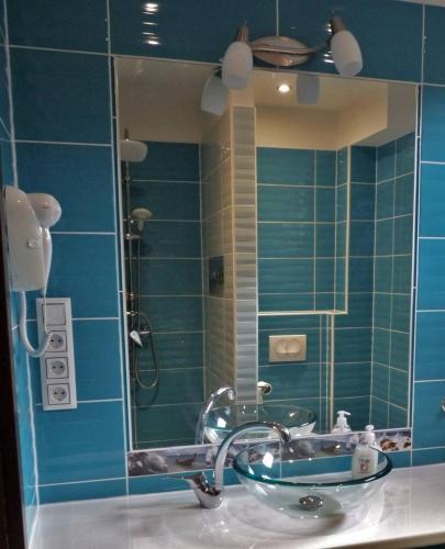 a bathroom with a sink and a shower with a mirror at Erika Vendégház in Mogyoród