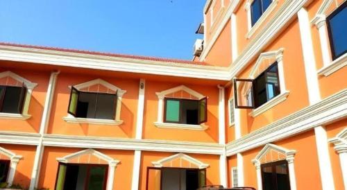 an orange building with windows on the side of it at Khamsaner Hotel in Vientiane