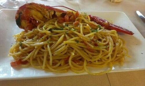 a white plate of pasta with a sausage at Hotel Villa Monica in Prata di Pordenone