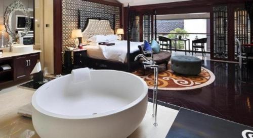 a bathroom with a tub and a bedroom with a bed at Eden Club House in Tongxiang