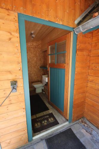 an outside view of a bathroom with a toilet and a door at Bootshaus Froschkönig übernachten über dem Weiher in Hundsdorf