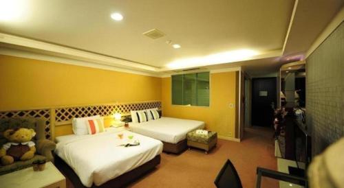 a hotel room with two beds and a couch at Metro Tourist Hotel Cheonan in Cheonan
