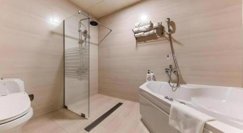 a bathroom with a shower and a toilet and a tub at Metro Tourist Hotel Cheonan in Cheonan